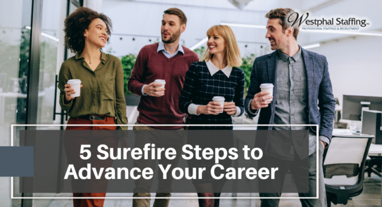 A group of employees walking together and chatting while holding coffee cups
