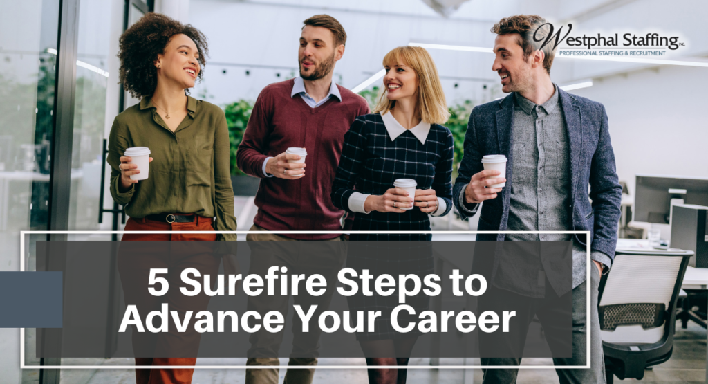 A group of employees walking together and chatting while holding coffee cups