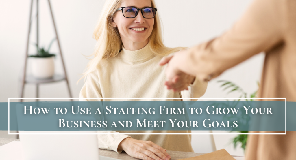 A woman sitting down at her desk shaking a hand
