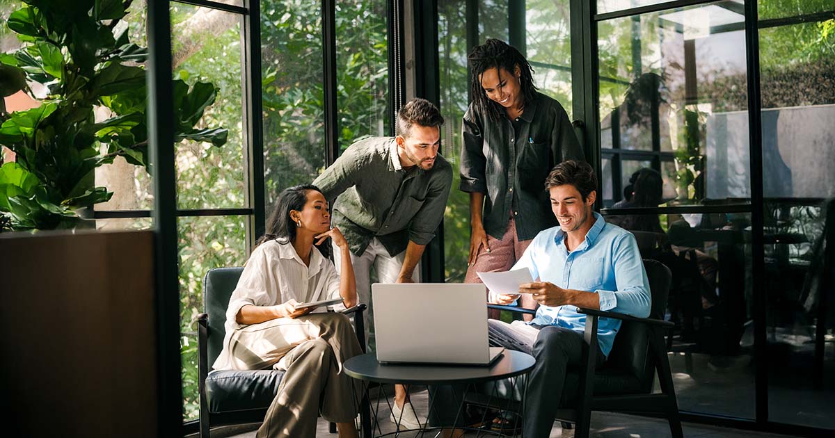 Group of young multi-ethnic startup business team collaborating on project in modern office