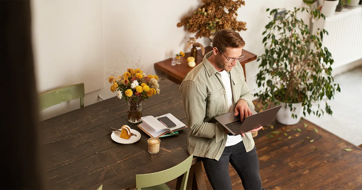 Man leaning on tablet while holding his laptop