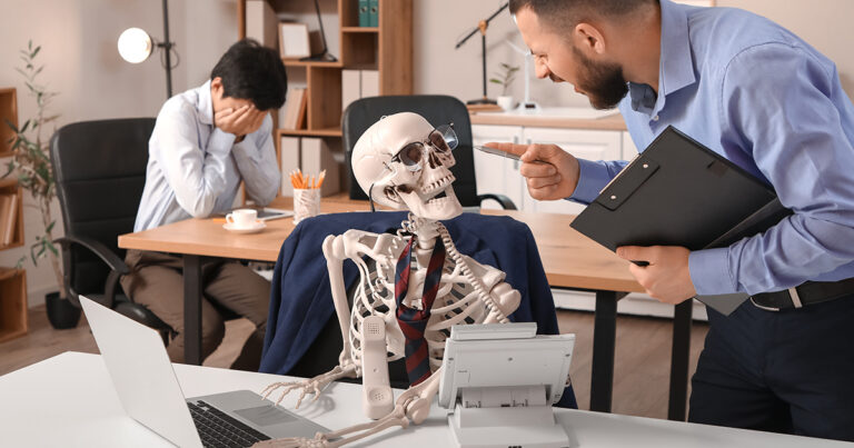 Angry businessman shouting at human skeleton in office