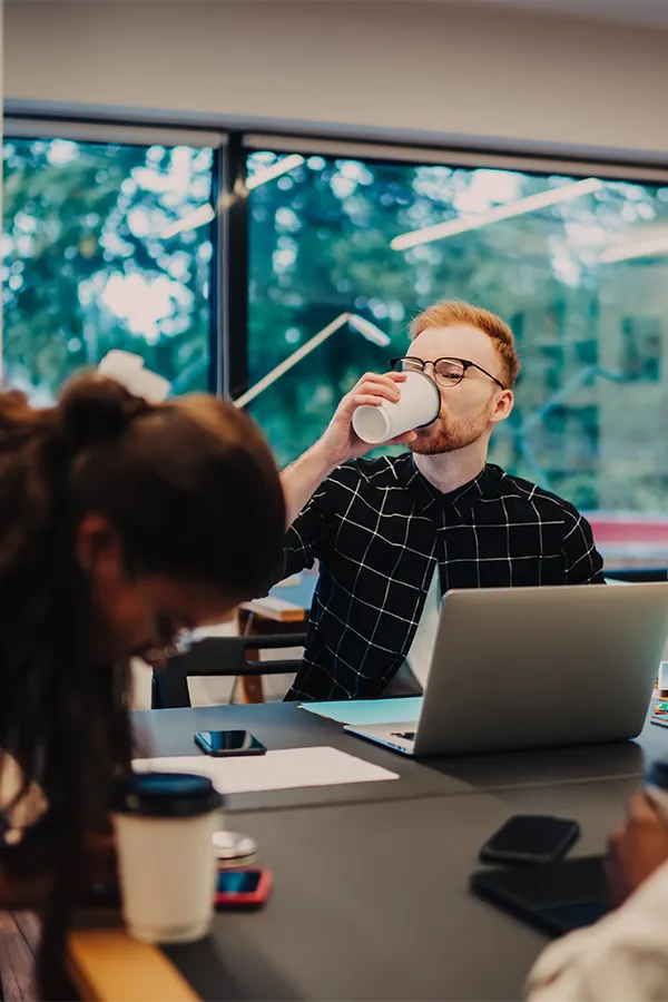 Man sipping his coffee in an office setting